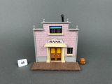 un petit bâtiment rose avec une enseigne sur la façade