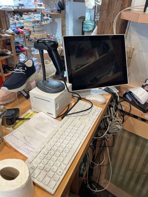 un bureau équipé d'un ordinateur, d'un clavier, d'une souris et d'un rouleau de papier toilette