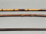 several old canes are lined up on a gray surface