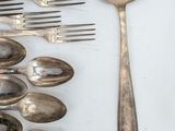 many silver spoons and spoon spoons on a table