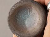 a hand holding a metal flaskt with writing on it