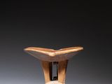 a small wooden object that is on a white surface
