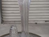 a glass vase and salt shaker sitting on a table