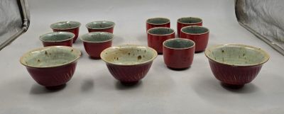 plusieurs bols et tasses rouges et verts posés sur une surface blanche