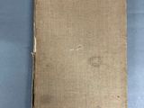 an old book sitting on top of a table next to a pair of scissors