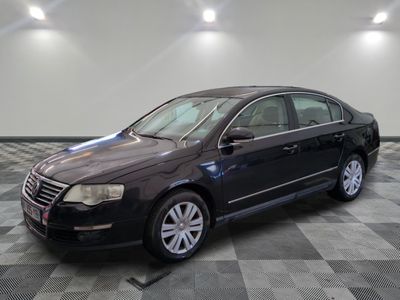 une photo d'une Volkswagen Passat noire garée sur un sol à carreaux
