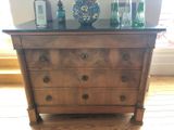 a dresser with bottles and a vase on top of it