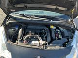 une voiture dont le capot est ouvert et dont le moteur se trouve dans le coffre