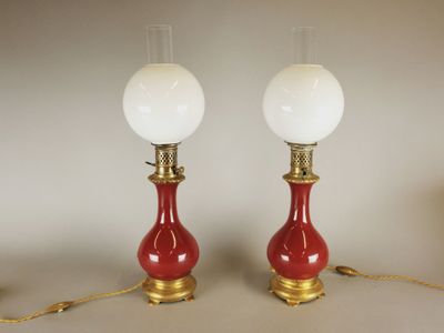 pair of red and gold table lamps with white glass shades