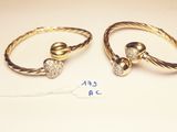 two gold rings with diamonds on them and a price tag on a table