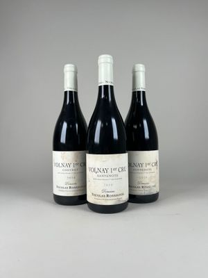trois bouteilles de vin rouge posées sur une table