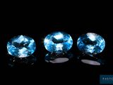 trois pierres précieuses de topaze bleue sur fond noir