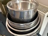 une pile de casseroles et de poêles posée sur une cuisinière