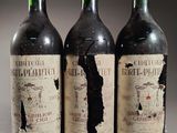trois bouteilles de vin rouge posées côte à côte sur une table