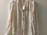 the shirt is hanging on a hanger on the wall