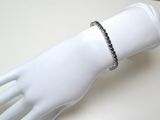 bracelet en diamants noirs et blancs sur la main d'un mannequin