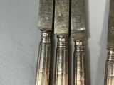 three silverware knives sitting on top of each other
