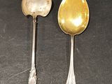 two spoons sitting next to each other on a table