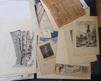 a pile of old papers and pictures on a table