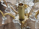 a chandelier that has a glass candle holder on it
