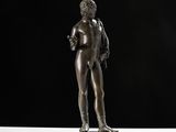 une statue en bronze représentant un homme debout sur un piédestal