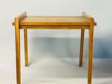 une petite table avec un plateau en bois sur fond blanc