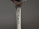 a silver spoon with a face on it on a table