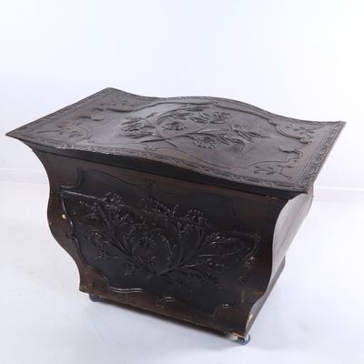 une vieille boîte en bois ornée d'un motif sculpté sur le devant