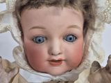 a close up of a doll wearing a bonnet