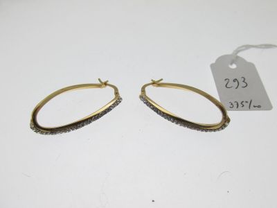 une paire de boucles d'oreilles créoles en or ornées de pierres noires et blanches
