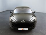 the front of a black sports car is parked in a room