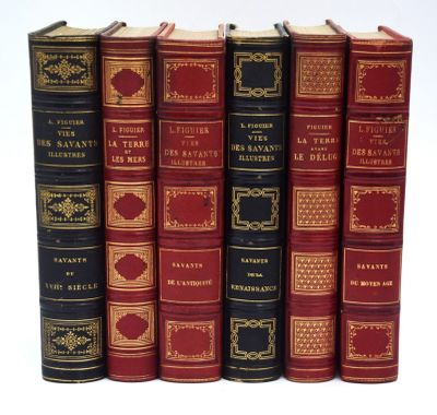 six livres rouges et noirs alignés sur une surface blanche