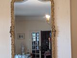 a mirror above a fireplace in a room with a chandelier