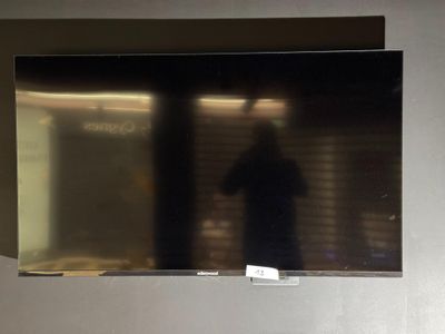 un homme debout devant un téléviseur à écran plat
