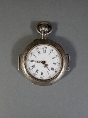 a silver pocket watch with roman numerals on the face