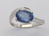 une bague ovale sertie d'un saphir bleu et de diamants, en or blanc 18 carats