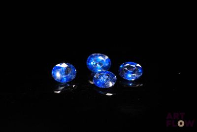 a close up of three blue sapphires on a black surface