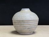 a white vase sitting on a table with a black background