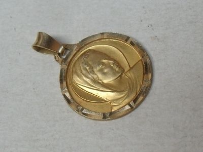a picture of a gold pendant with a picture of a woman on it