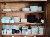 de nombreuses assiettes et bols sur les étagères du placard