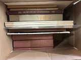 plusieurs livres empilés dans une boîte