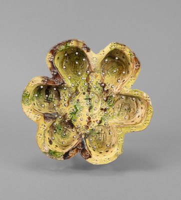 a close up of a flower shaped object on a gray surface