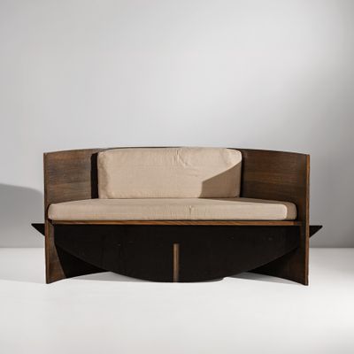 une photo d'un canapé en bois sur lequel est posé un coussin beige