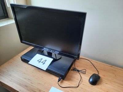 un écran d'ordinateur posé sur un bureau, avec une souris dessus