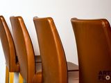 several brown leather chairs are lined up against a white wall