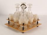 bottles and glasses on a wooden tray with a mirror in the background