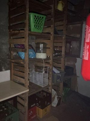 a room with a fire extinguisher, shelves, and a fire extinguisher in the corner
