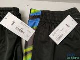 two pairs of men ' s athletic pants with price tags on them