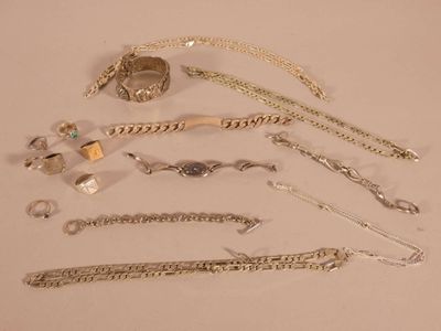 a lot of silver jewelry on a white surface