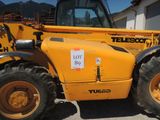 un tracteur jaune garé devant un bâtiment